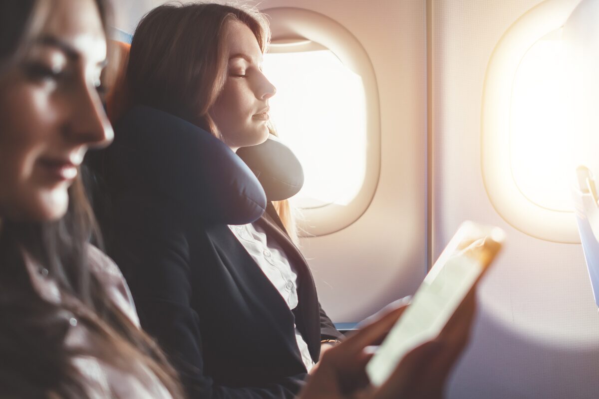 Woman traveling by plane with comfort pillow